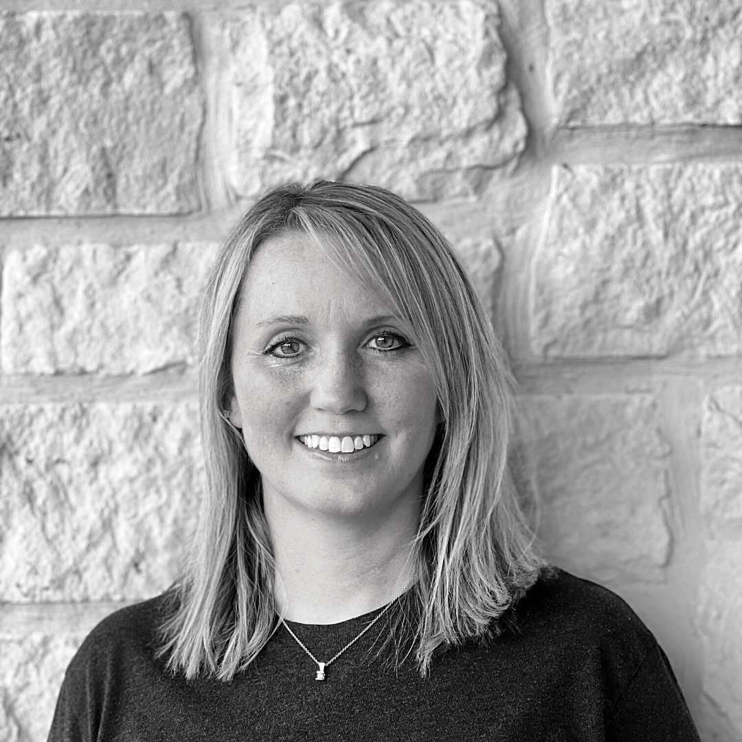 Co-Founder Michelle Head Shot in black & white against white rock wall - Wag Trendz