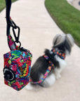 Dog Poo Bag Holder - Shih Tzu mix wearing multi-colored street graffiti dog harness with matching dog leash and poo bag holder attached - sitting outdoors on concrete - Wag Trendz