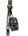 Dog Poop Bag Holder - Skull Society with multicolored graphics in yellow, blue, purple with black background - attached to the matching leash - against solid white background - Wag Trendz