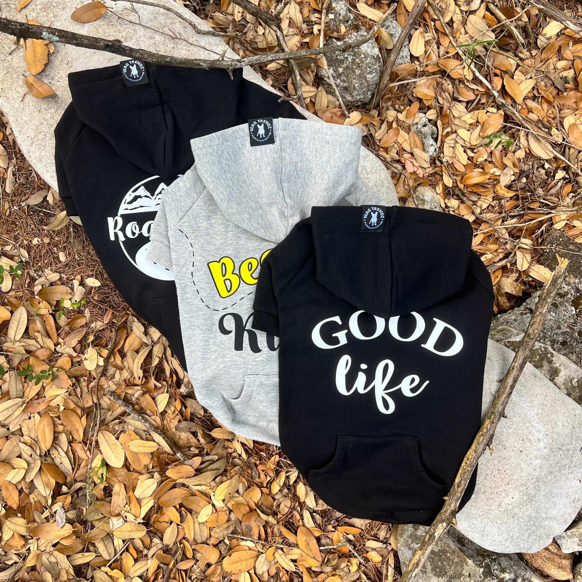 Dog Hoodie - Hoodies For Dogs - &quot;Bee Kind&quot; &quot;Road Trip&quot; &amp; &quot;Good Life&quot; dog hoodies in gray and black laying on a log outdoors against a scenic fall background - Wag Trendz