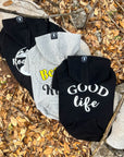 Dog Hoodie - Hoodies For Dogs - "Good Life", "Bee Kind", and "Road Trip" dog hoodie in black and gray - back view - outdoors laying on a log in a scenic fall background with brown leaves - Wag Trendz