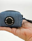 Dog Poop Bag Holder - Downtown Denim - blue jean with a black zipper and black rubber logo dispenser on front - sitting in the hand of a model against a solid white background - Wag Trendz