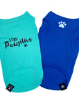 Dog T-Shirt - "Stay Pawsitive" - Teal and Royal Blue dog t-shirt - Stay Pawsitive lettering in black on teal t-shirt and a paw print emoji in white on chest of blue t-shirt - against solid white background - Wag Trendz