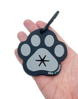 Poop Buddy - black and gray resin dog paw - laying in the palm of a hand - against solid white background - Wag Trendz