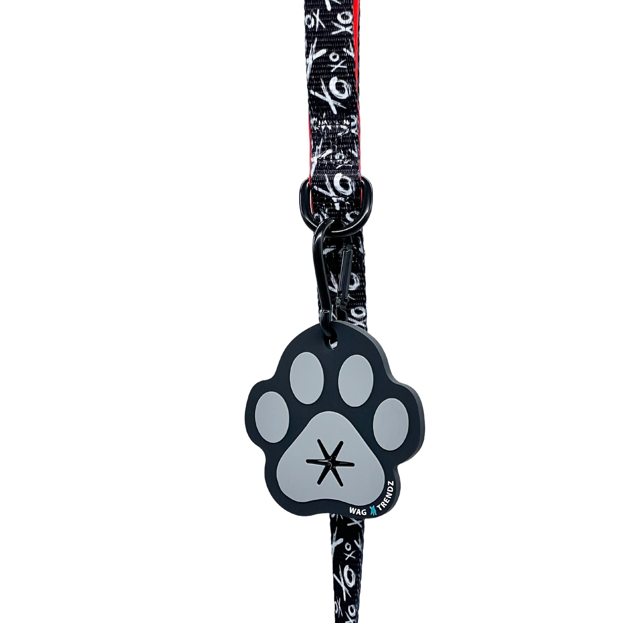 Poop Buddy - black and gray resin dog paw - hanging on a black & white XO dog leash with red accents - against white background - Wag Trendz