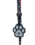 Poop Buddy - black and gray resin dog paw - hanging on a black & white XO dog leash with red accents - against white background - Wag Trendz